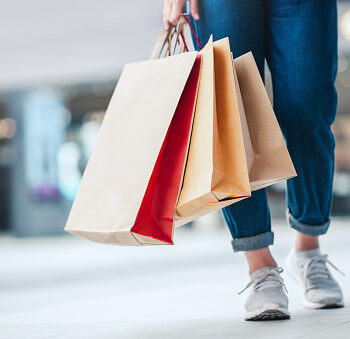 Closeup - Woman holding sale shopping bags. Consumerism, shopping, lifestyle concept